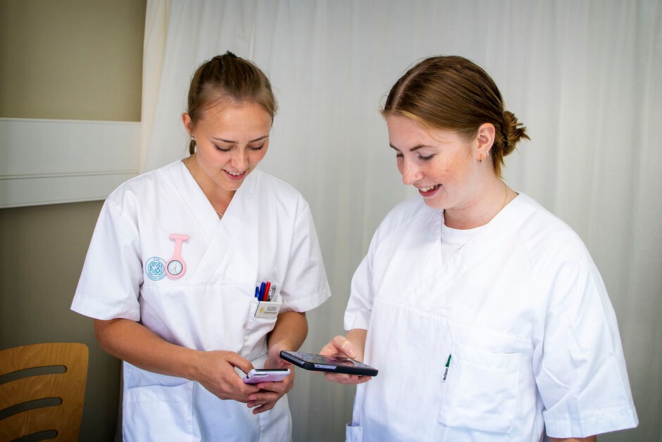 two female clinical students see the phone in the hospital.