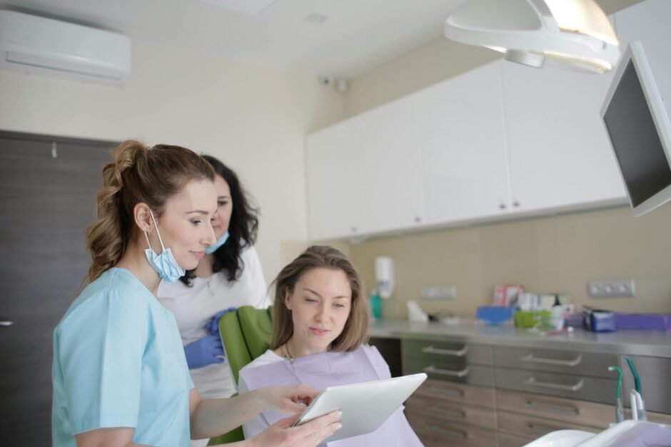 three woman view ipad at dentist